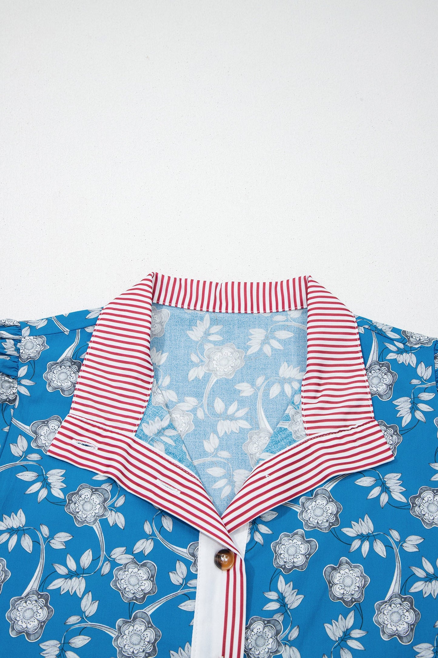 Blusa de manga corta con cuello abotonado, ribete a rayas y estampado floral retro azul