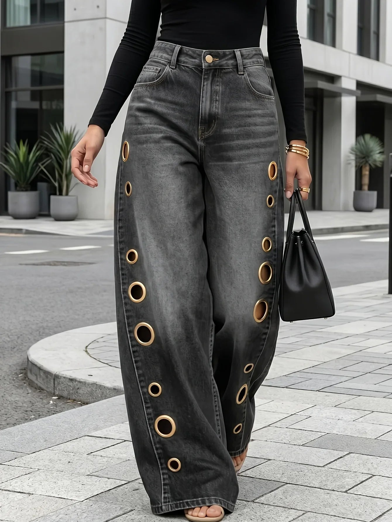 Retro-style wide-leg jeans with metallic eyelets, high-waisted, loose, floor-length fit, gradient eyelets of varying sizes on both sides, distressed washed finish, classic front and back pockets, perfect for everyday casual w
