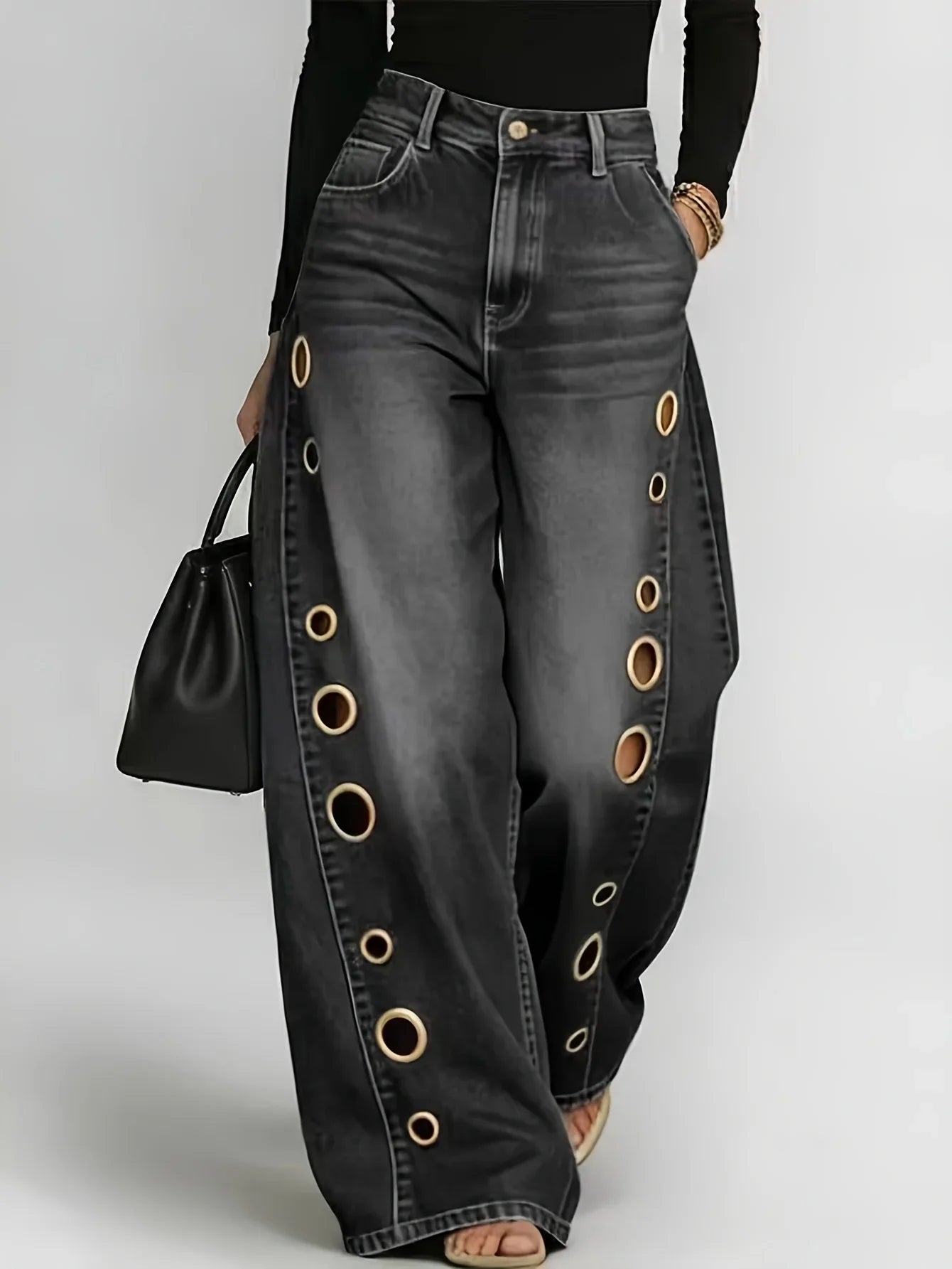 Retro-style wide-leg jeans with metallic eyelets, high-waisted, loose, floor-length fit, gradient eyelets of varying sizes on both sides, distressed washed finish, classic front and back pockets, perfect for everyday casual w