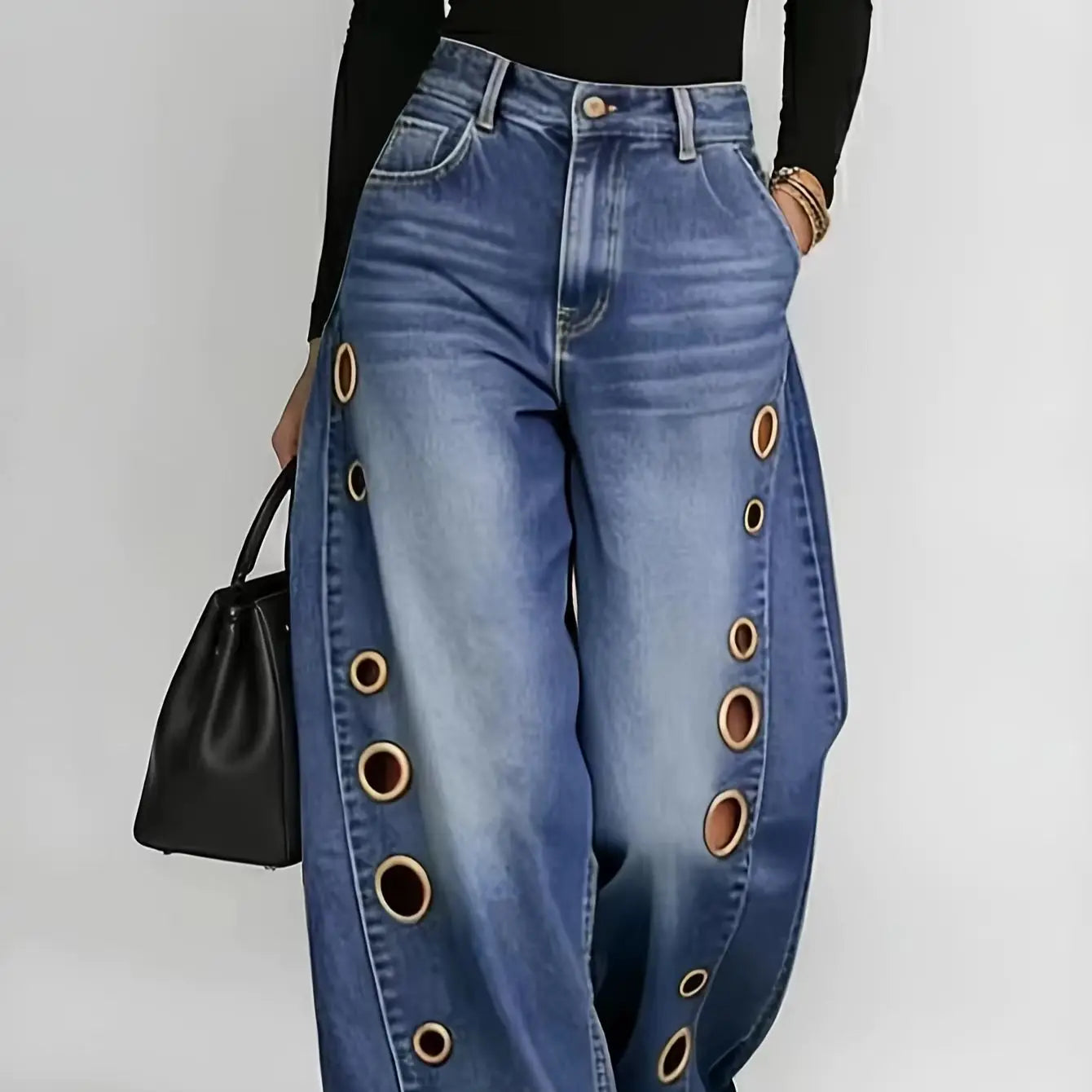 Retro-style wide-leg jeans with metallic eyelets, high-waisted, loose, floor-length fit, gradient eyelets of varying sizes on both sides, distressed washed finish, classic front and back pockets, perfect for everyday casual w