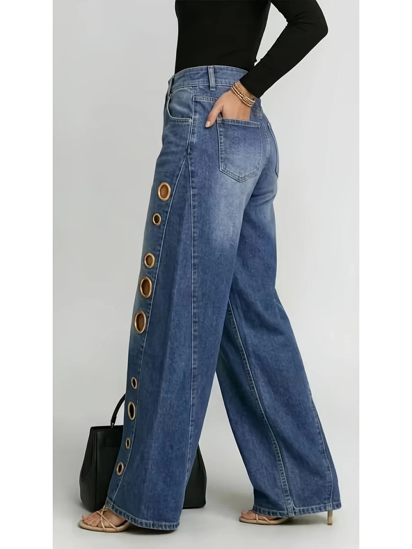 Retro-style wide-leg jeans with metallic eyelets, high-waisted, loose, floor-length fit, gradient eyelets of varying sizes on both sides, distressed washed finish, classic front and back pockets, perfect for everyday casual w