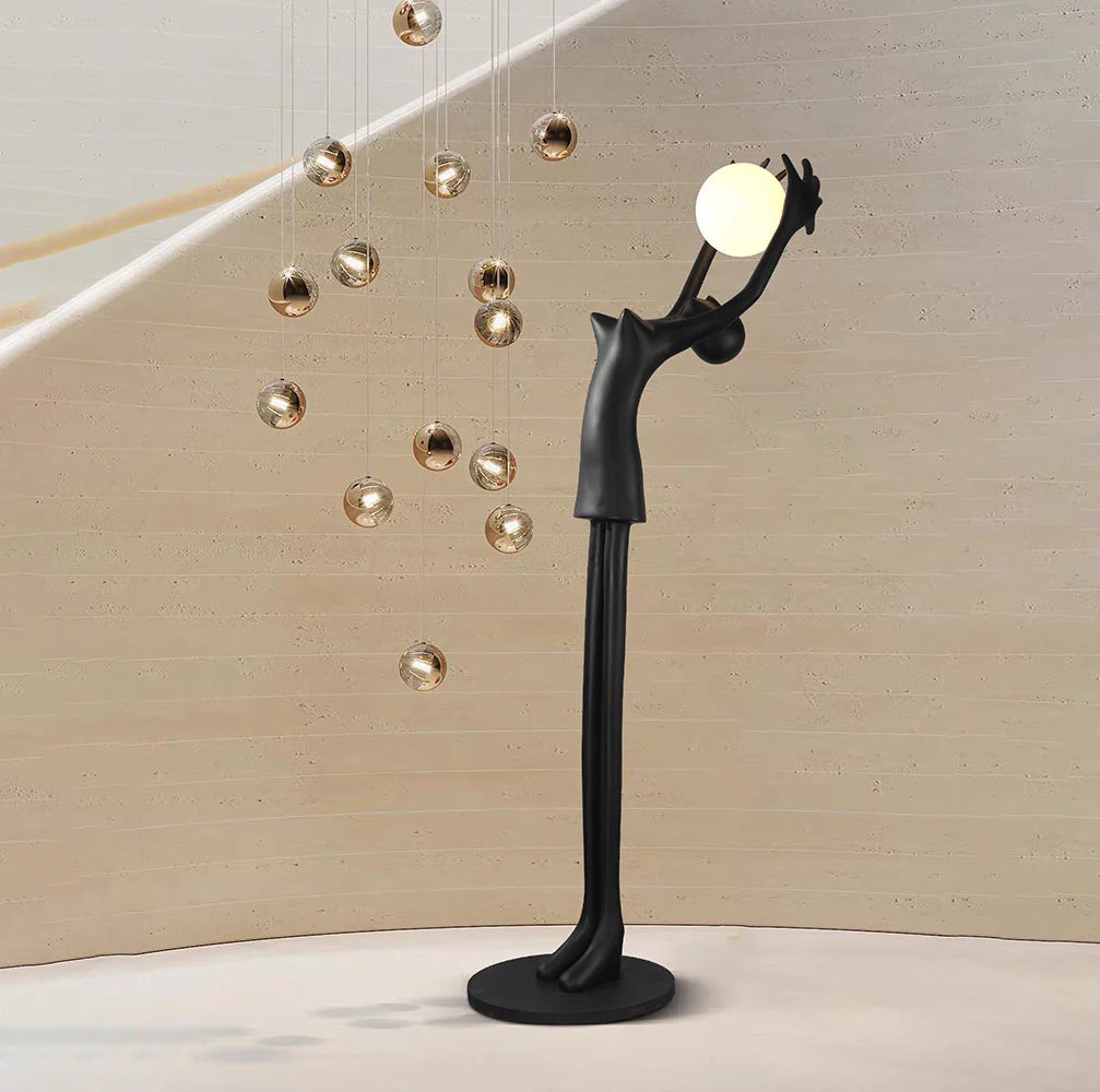 Lámpara de pie con personaje de escultura que sostiene una pelota