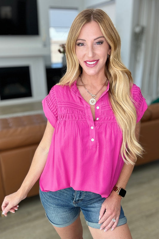 Blusa abotonada con detalles plisados en rosa fucsia