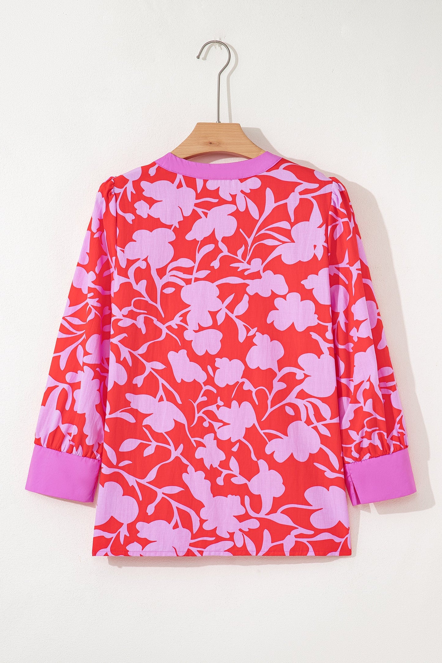 Blusa roja con estampado floral, cuello en V con abertura y manga pulsera con puño