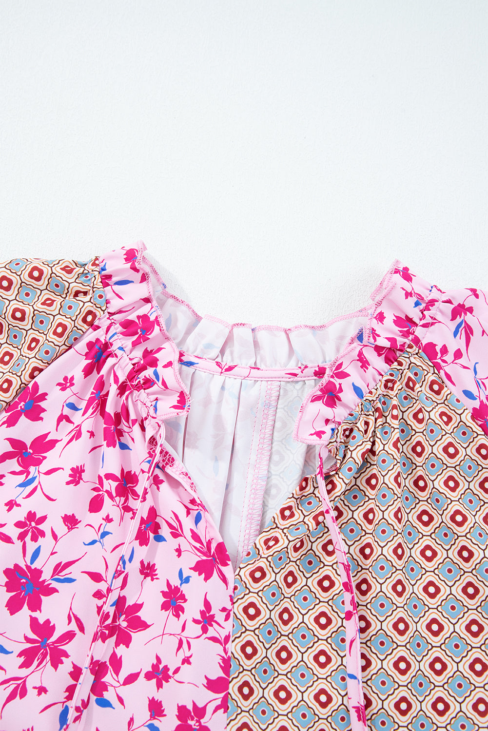 Blusa rosa estilo bohemio con retales florales mixtos, hombros caídos y mangas abullonadas