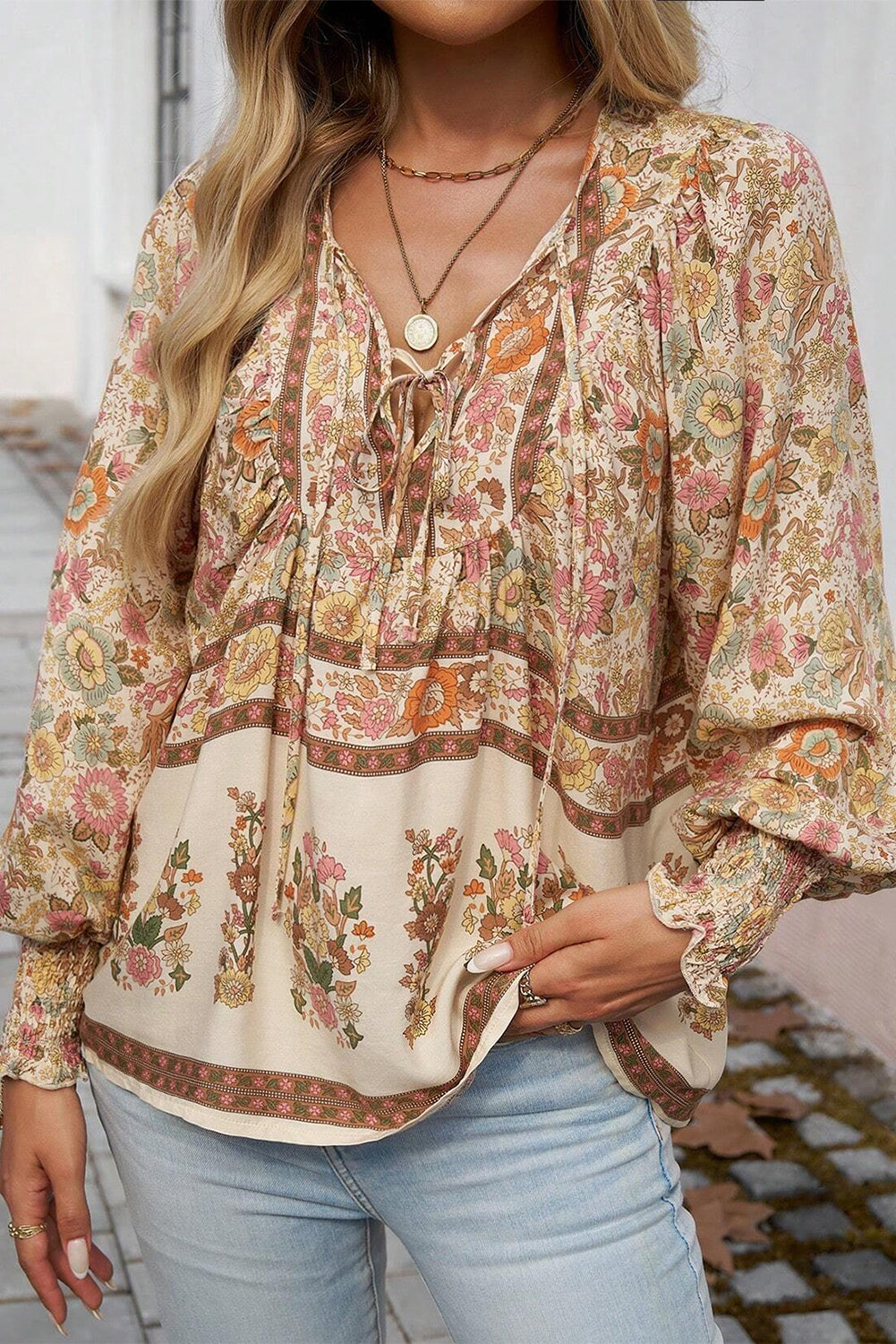 Blusa con estampado floral amarillo, lazo en el cuello y mangas farol
