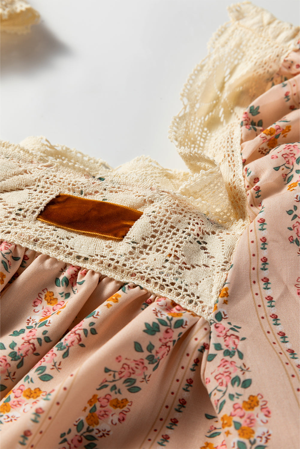 Minivestido suelto de manga larga con estampado floral caqui, lazo de terciopelo en contraste y encaje.