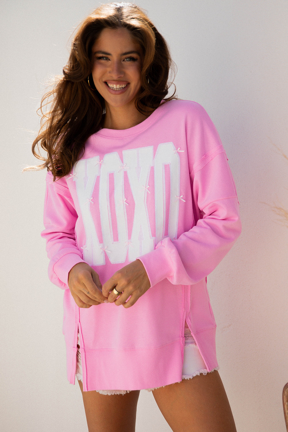 Sudadera holgada con lentejuelas de lazo rosa, gráfico de letras XOXO y costuras expuestas