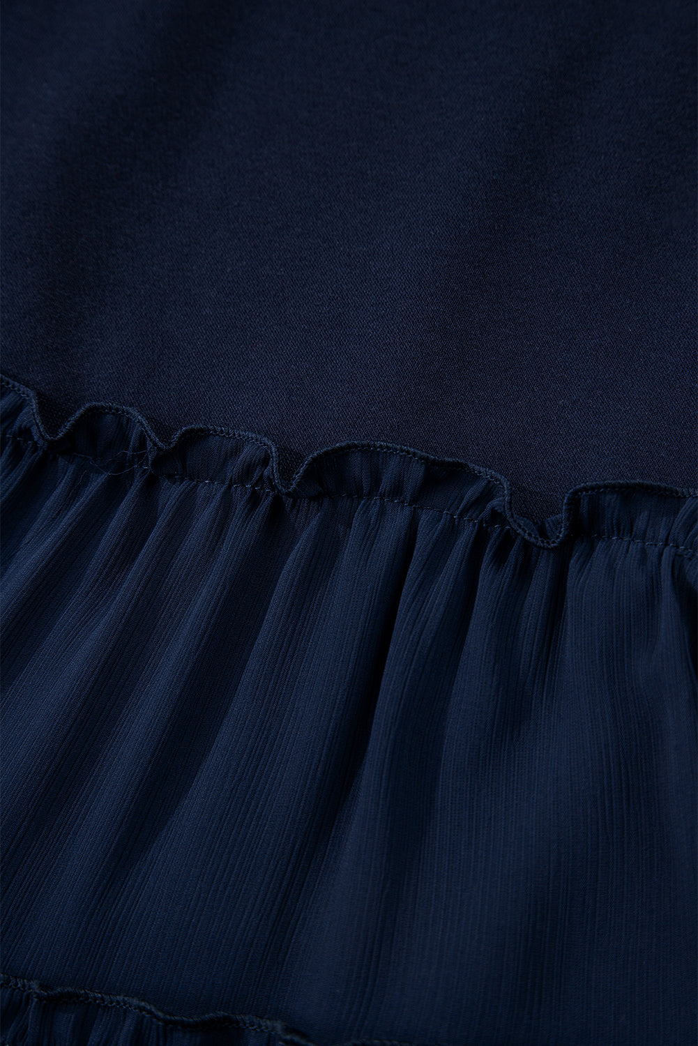 Top de talla grande azul marino con cuello redondo acanalado y volantes escalonados