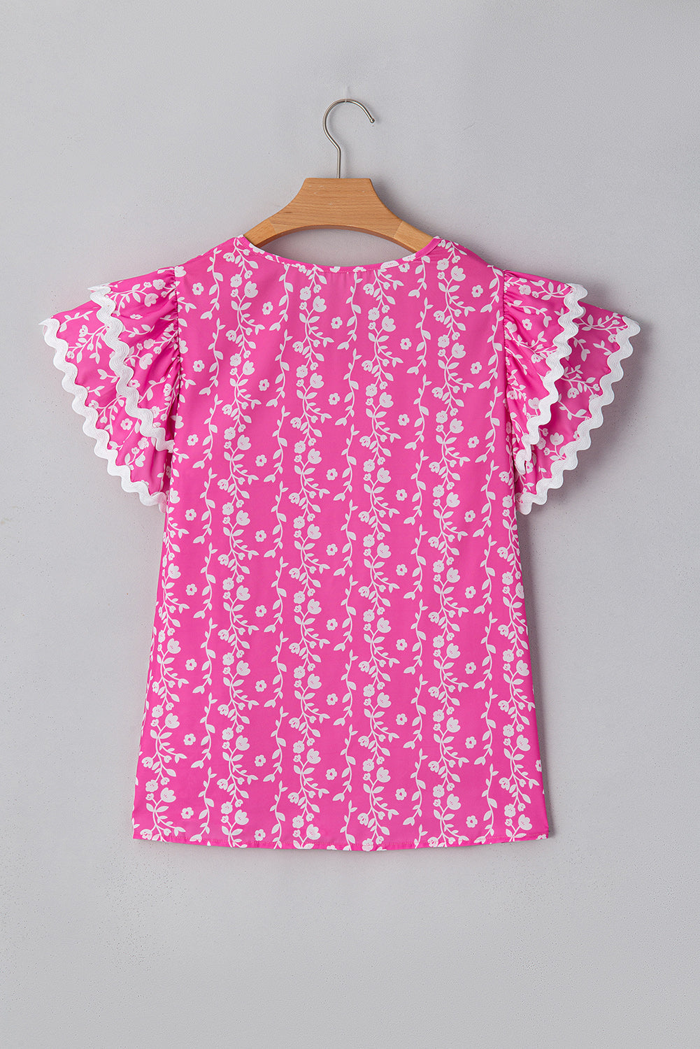 Blusa de cuello de pico con volantes escalonados y ribete de zig-zag con estampado floral rosa