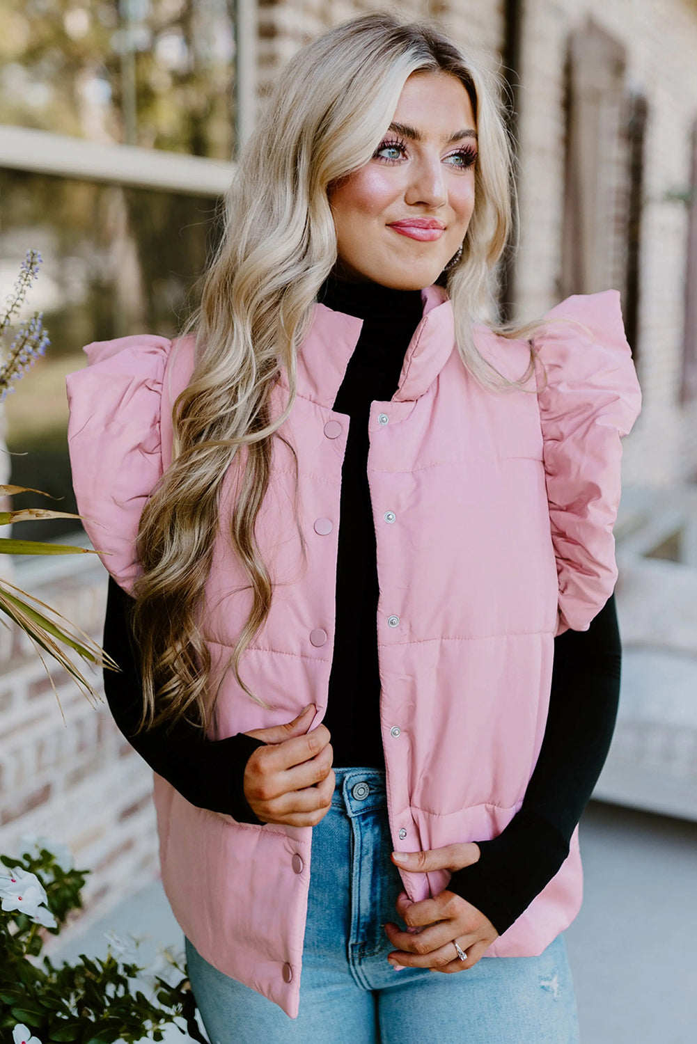 Chaleco acolchado rosa con cuello alto, mangas con volantes y botones a presión