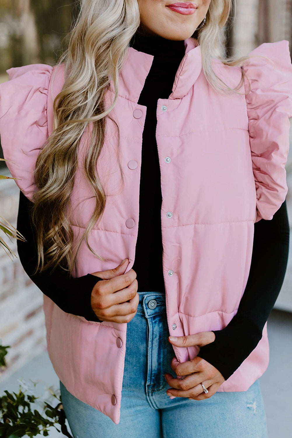 Chaleco acolchado rosa con cuello alto, mangas con volantes y botones a presión