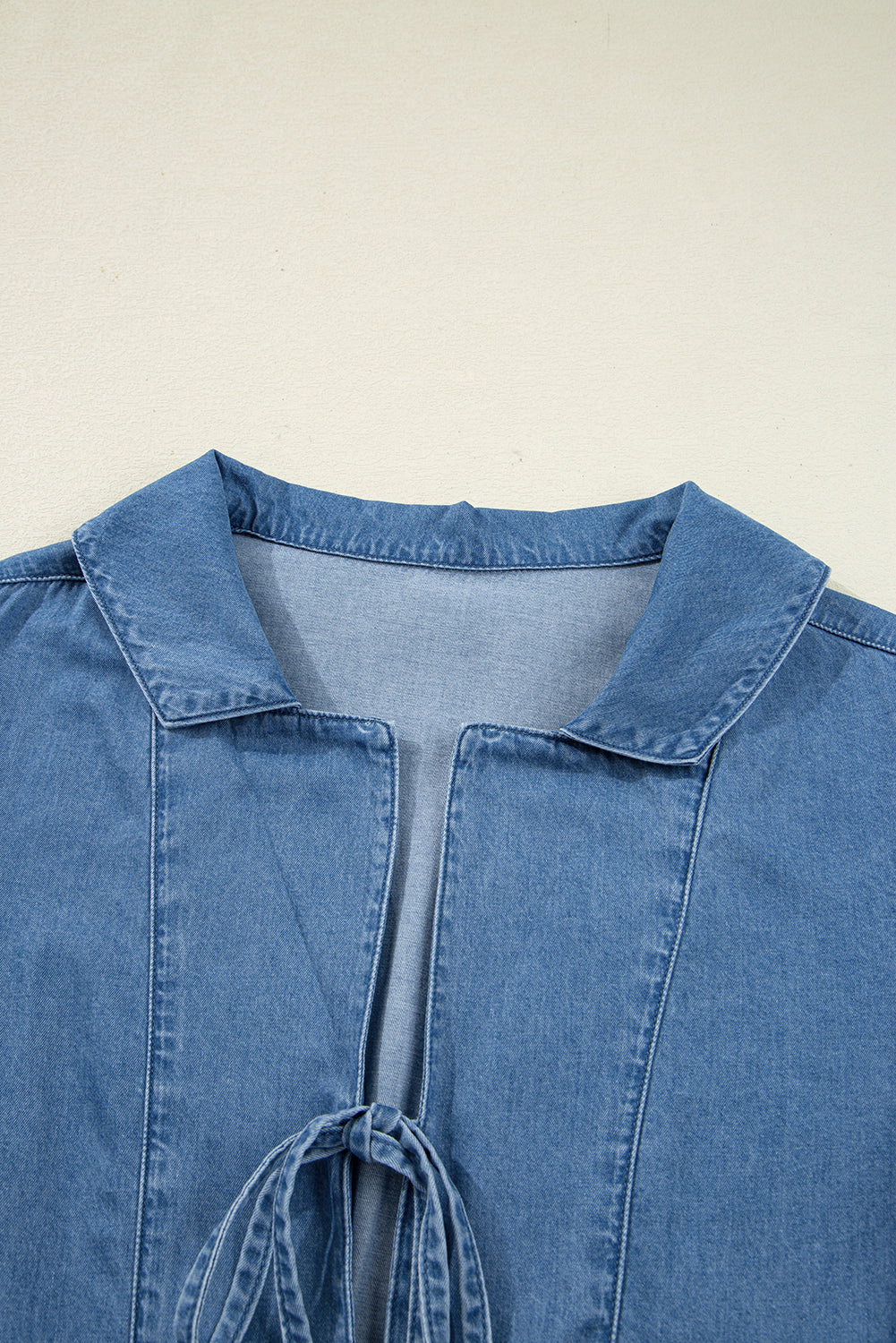 Top péplum atado con manga globo, cuello solapa y denim azul anochecer