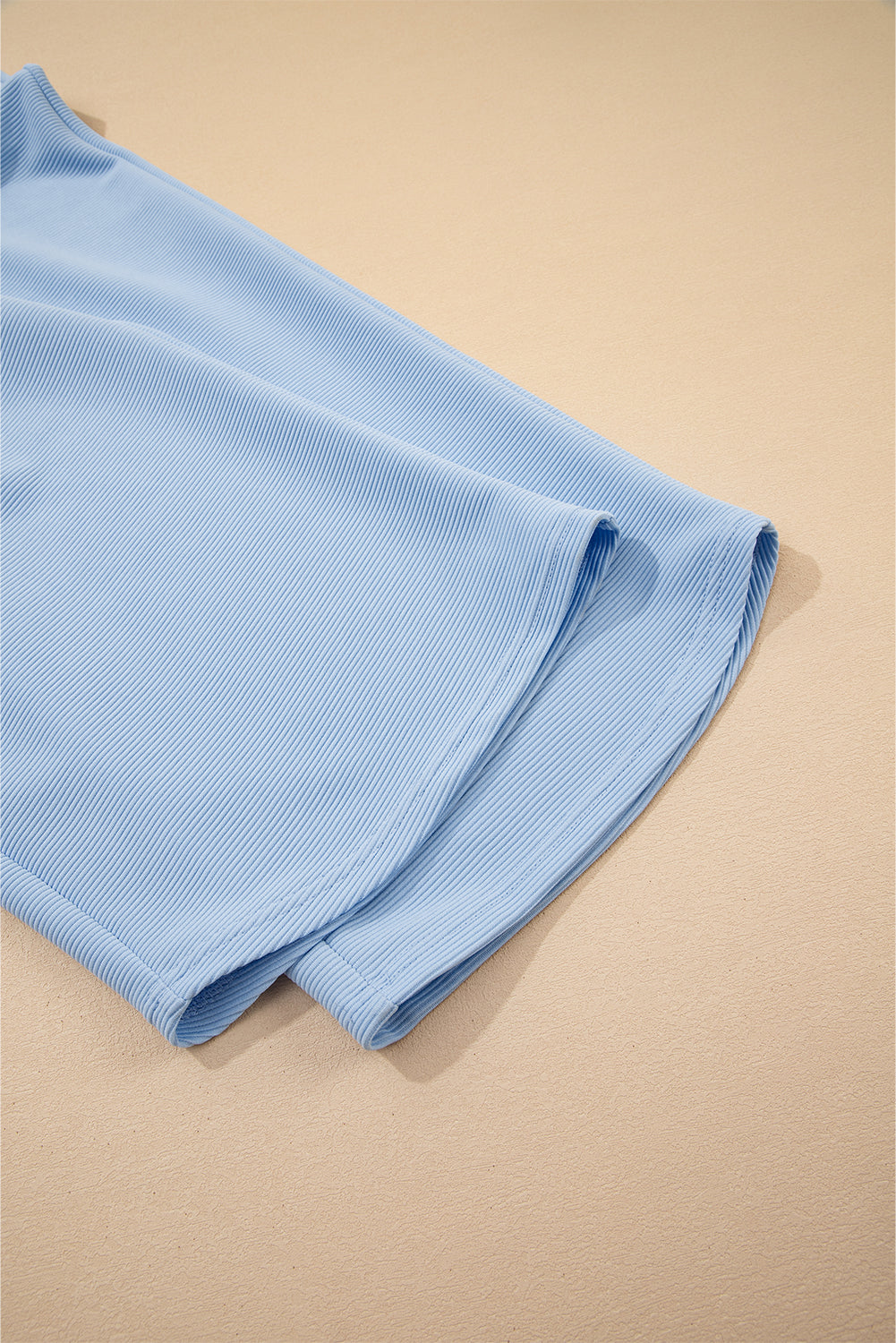Conjunto de top con cremallera, mangas con volantes y textura azul cielo, y pantalón de pernera ancha