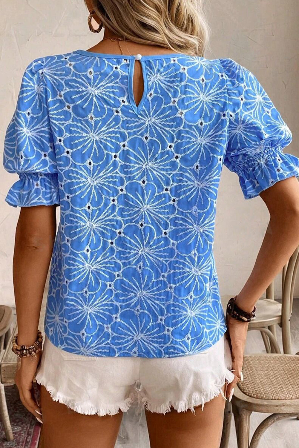 Blusa celeste con bordado de flores, ojales y manga corta abullonada con volantes