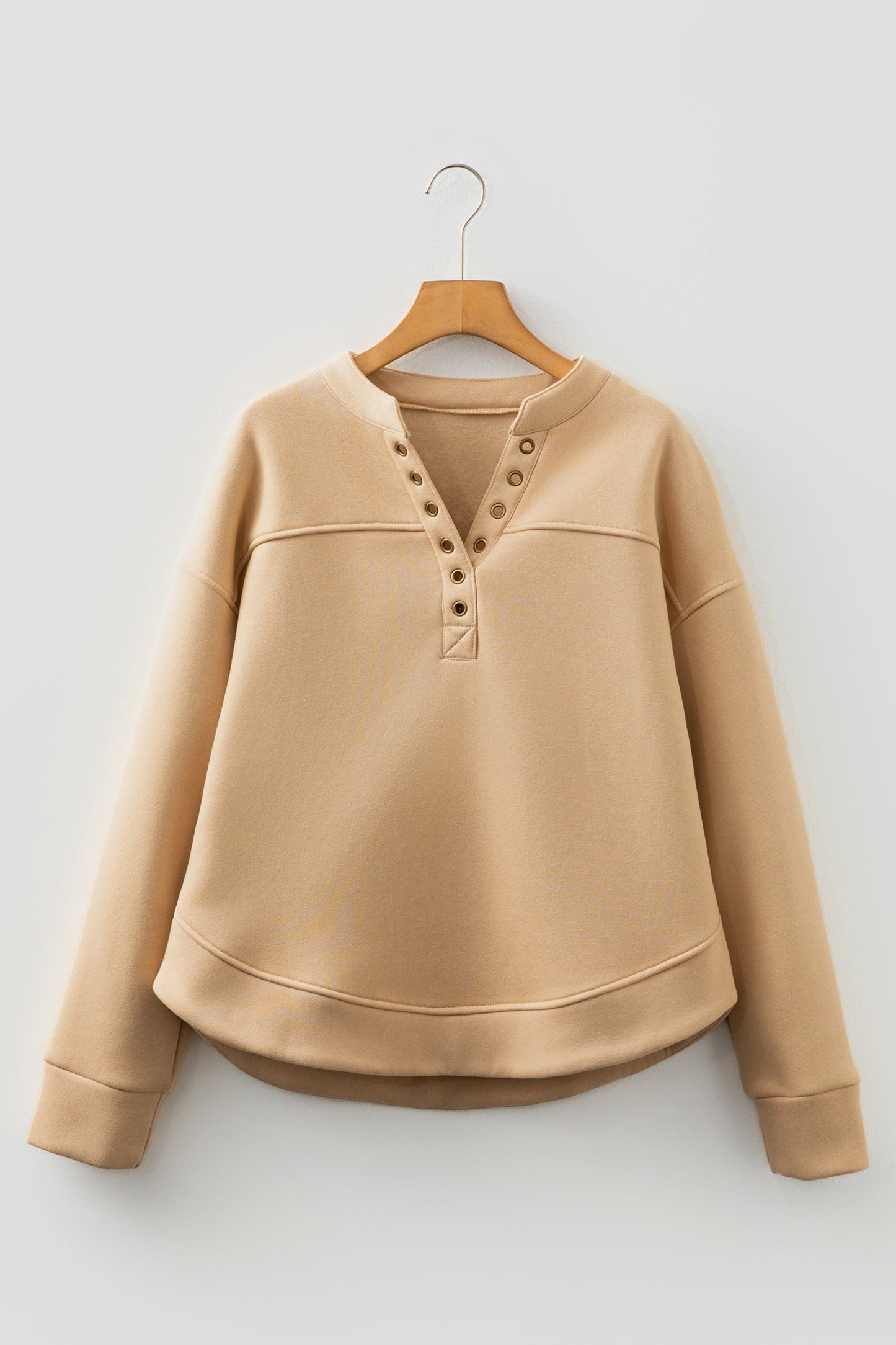 Sudadera con cuello de pico, detalles de ojales y color beige francés claro