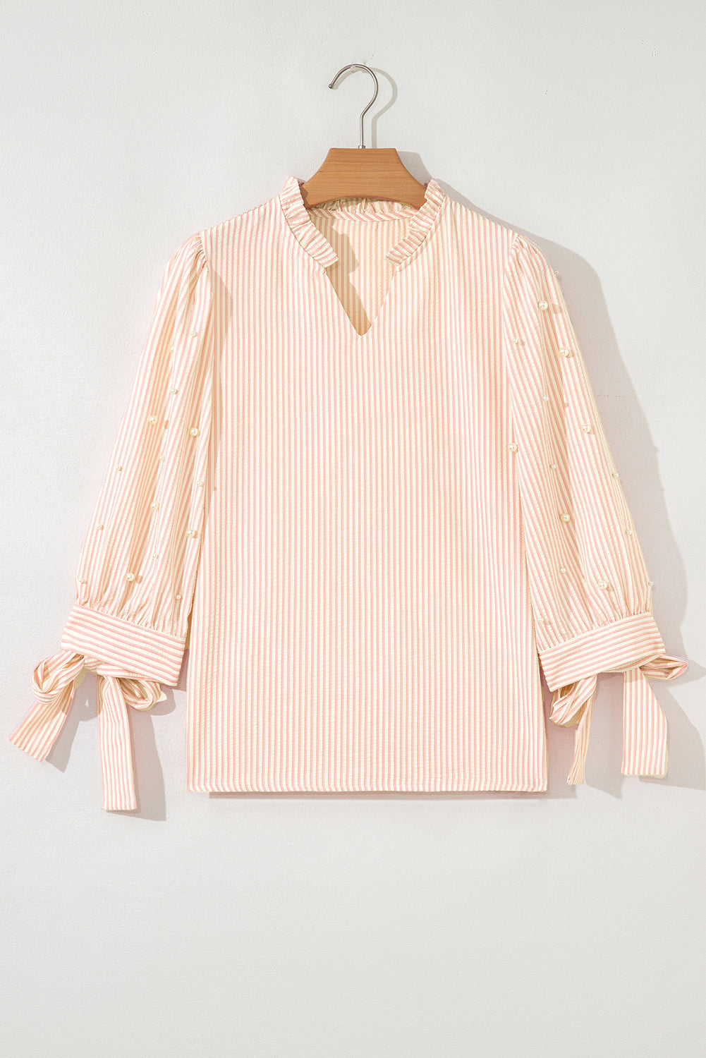 Blusa con cuello en V, manga abullonada, lazo a rayas rosas y adorno de perlas