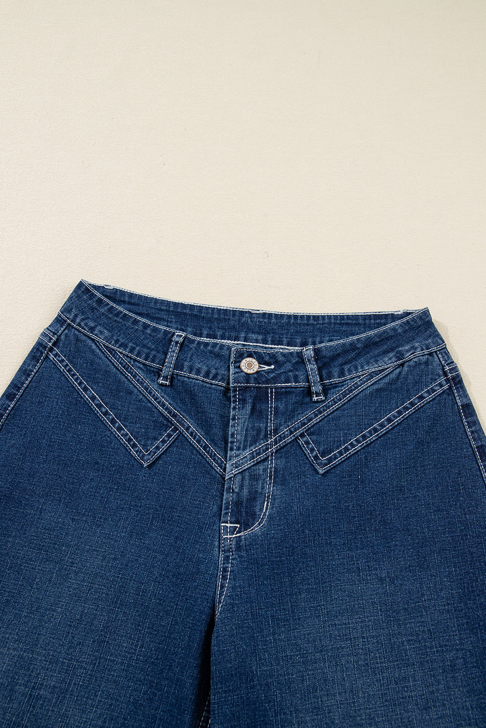 Vaqueros azules con pespuntes, detalle en la cintura y dobladillo vuelto