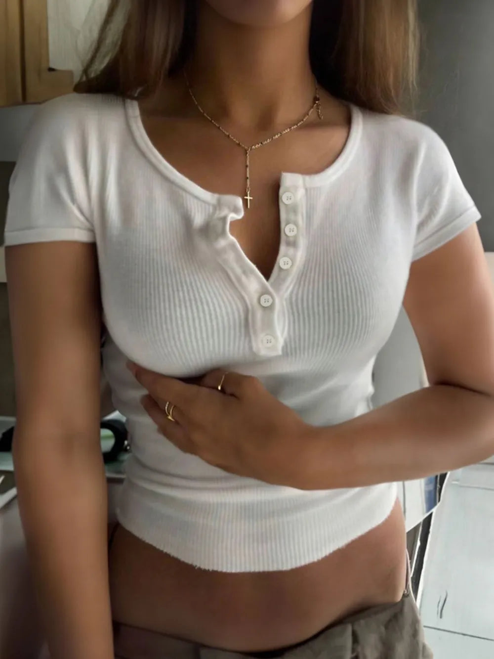 Camiseta de manga corta con cuello redondo, detalle de botones y textura acanalada