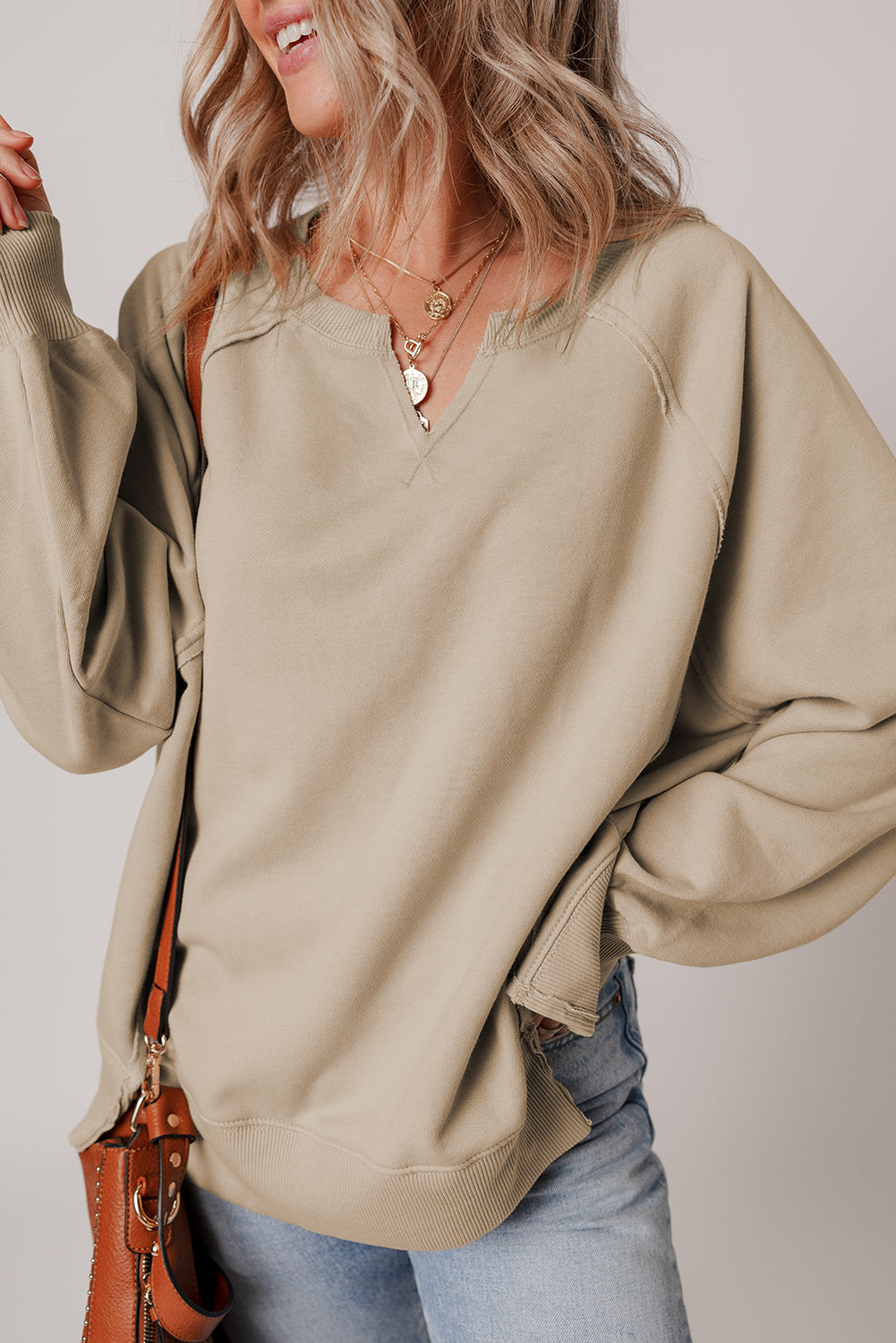 Sudadera con bajo deshilachado, costuras expuestas, manga raglán y aberturas laterales color pergamino