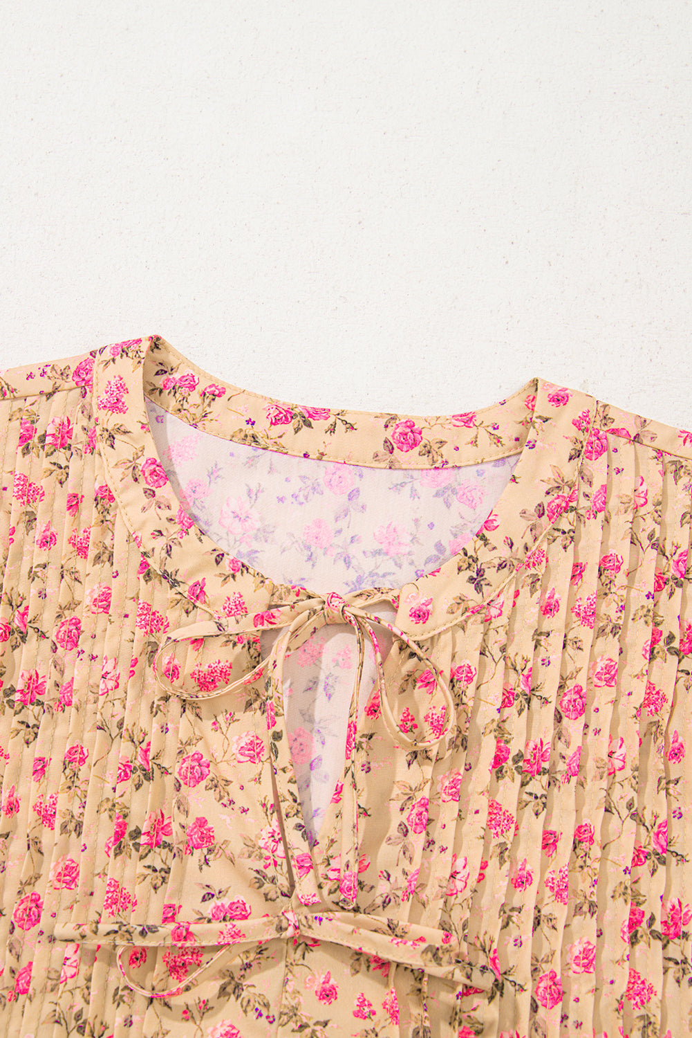 Blusa de color beige francés claro con estampado floral, lazo, pliegues en el busto y media manga abullonada