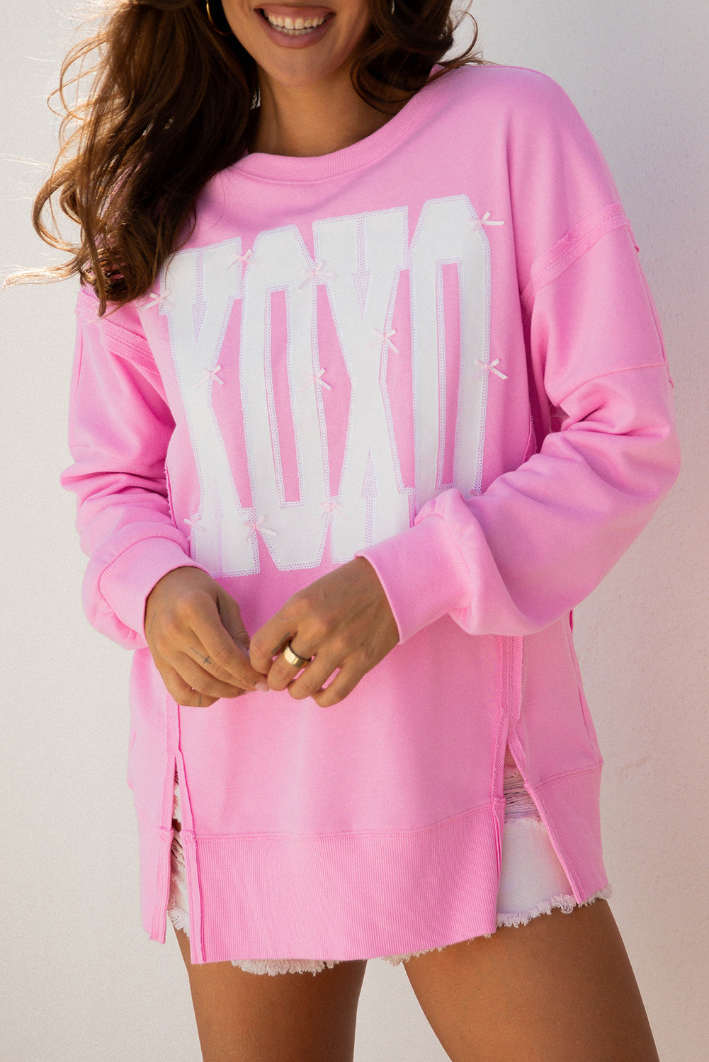 Sudadera holgada con lentejuelas de lazo rosa, gráfico de letras XOXO y costuras expuestas