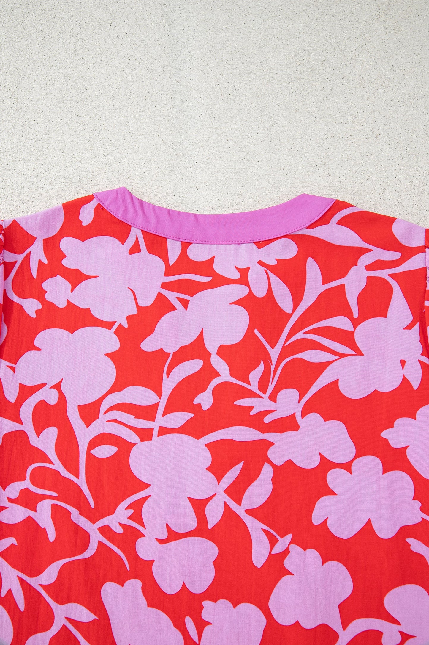Blusa roja con estampado floral, cuello en V con abertura y manga pulsera con puño