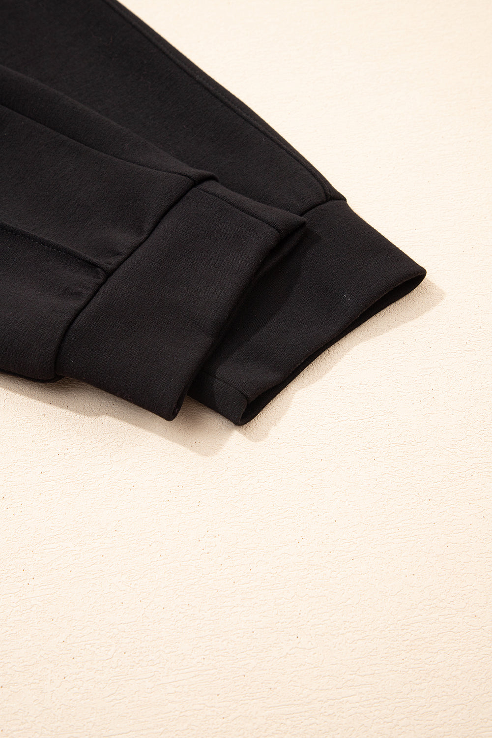 Pantalones joggers pitillo con cordón y detalles de costura expuesta, en color negro