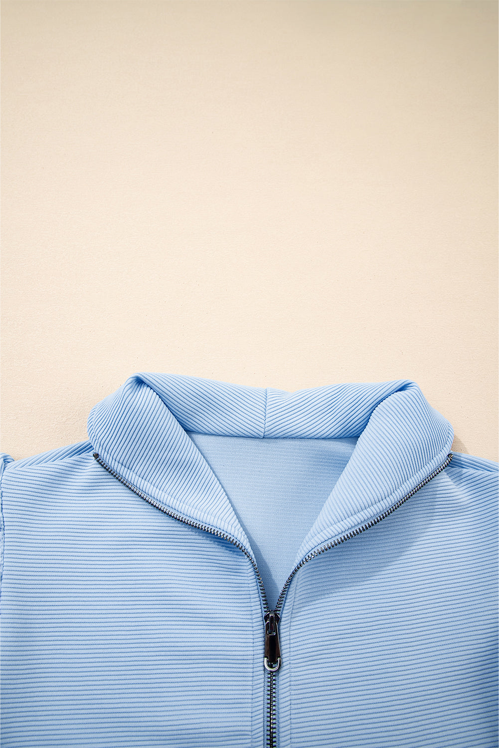 Conjunto de top con cremallera, mangas con volantes y textura azul cielo, y pantalón de pernera ancha