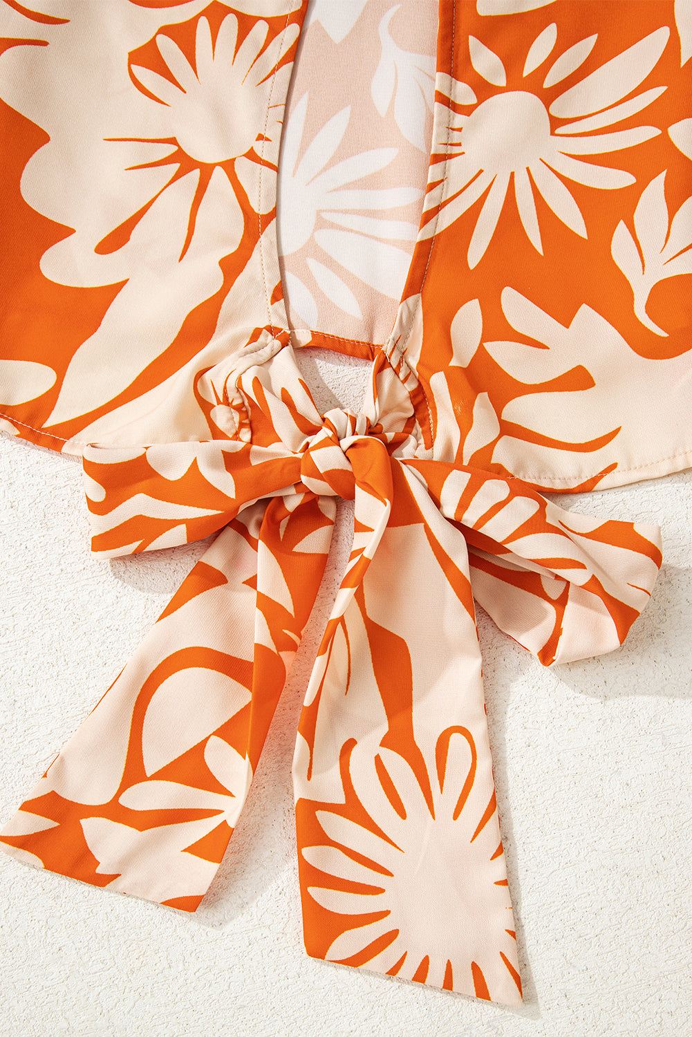 Blusa naranja de manga larga con estampado floral, nudo y espalda abierta