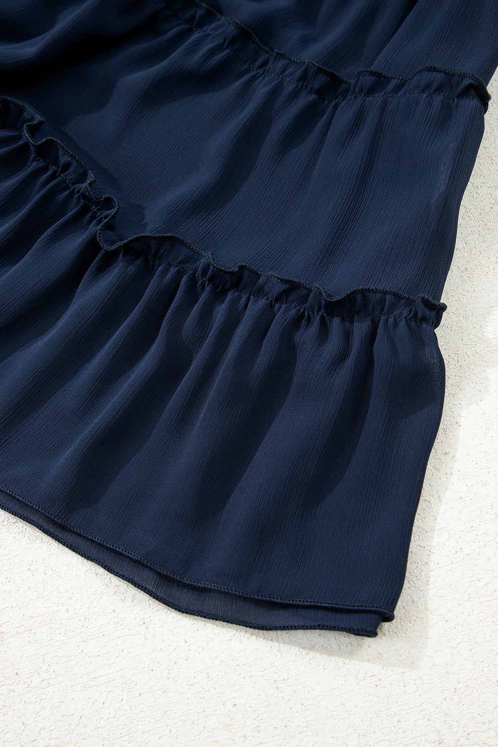 Top de talla grande azul marino con cuello redondo acanalado y volantes escalonados