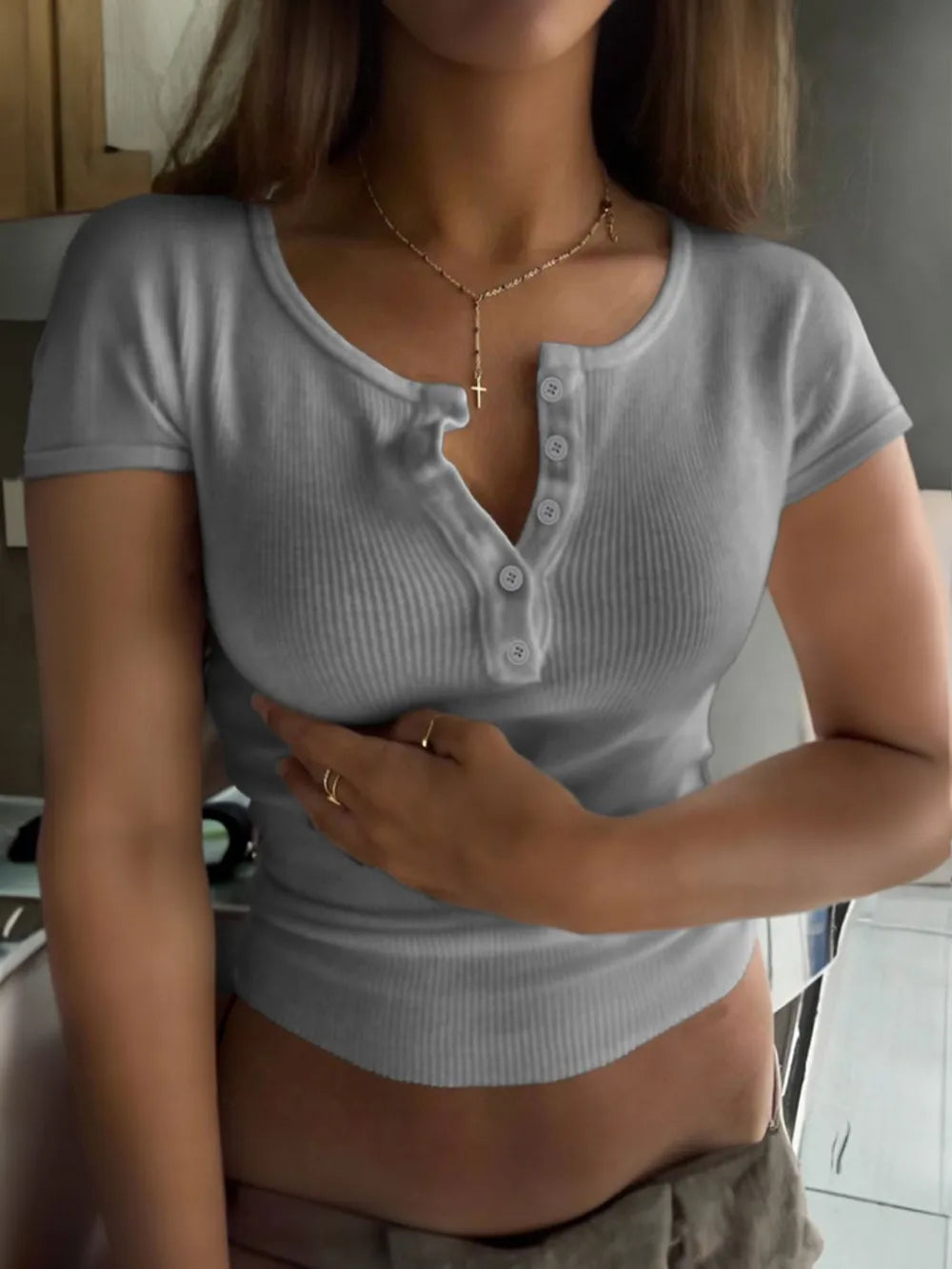 Camiseta de manga corta con cuello redondo, detalle de botones y textura acanalada