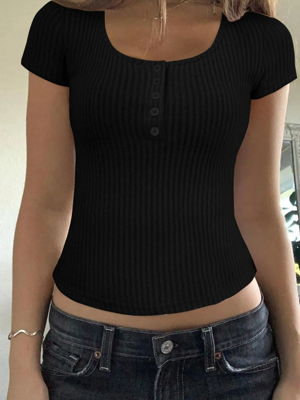 Camiseta de manga corta con cuello redondo, detalle de botones y textura acanalada