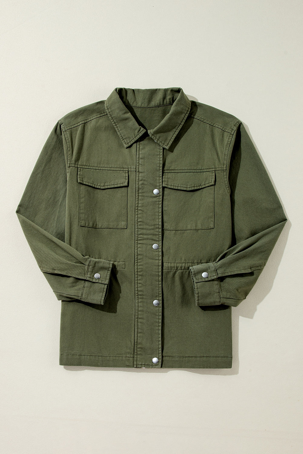 Chaqueta color verde musgo con cremallera, botones a presión, cintura ajustada y cuello.