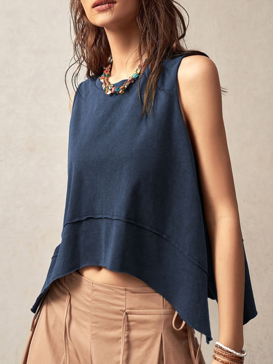 Camiseta sin mangas con cuello redondo, costura expuesta y abertura lateral