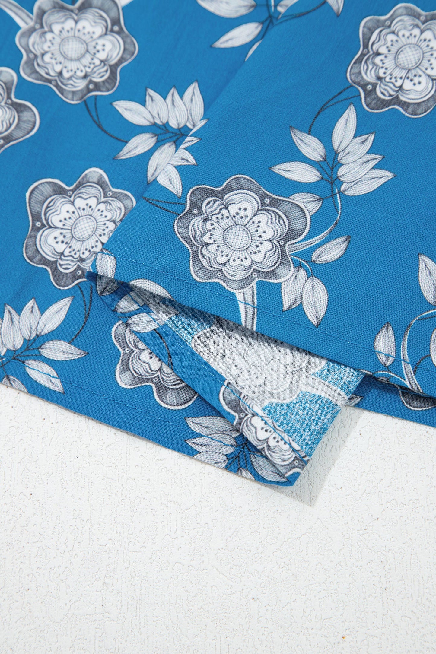 Blusa de manga corta con cuello abotonado, ribete a rayas y estampado floral retro azul